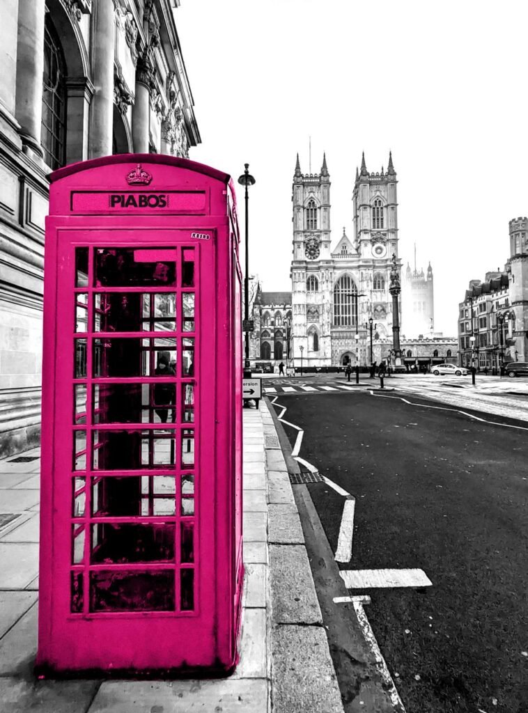 Telephone booth de color magenta con fondo ciudad blanco y negro